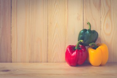 Ahşap masa arkasında tatlı biber resmi.