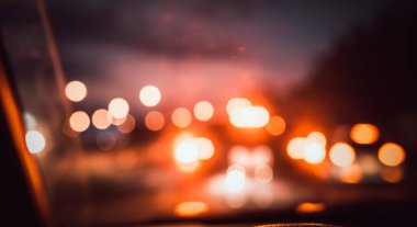 Arka plan kullanımı için gece vakti araba kullanan insanların klasik ton bulanık görüntüsü. (içeriden fotoğraf çek)