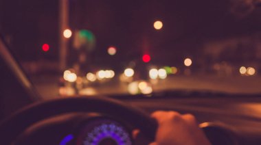 Arka plan kullanımı için gece vakti araba kullanan insanların klasik ton bulanık görüntüsü. (içeriden fotoğraf çek)