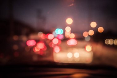 Arka plan kullanımı için gece vakti araba kullanan insanların klasik ton bulanık görüntüsü. (içeriden fotoğraf çek)