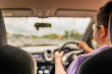 Arkaplan kullanımı için gündüz vakti araba kullanan insanların bulanık görüntüsü .