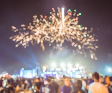 Gece festivalinde Bokeh 'in sahne performansı ve arka plan kullanımı için havai fişeklerle insanların klasik ton bulanıklığı.