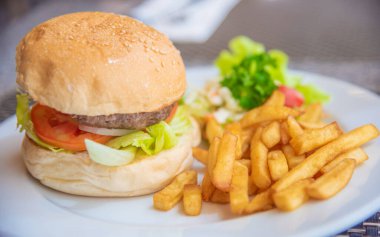 Masada taze sebzeli etli hamburger resmi.