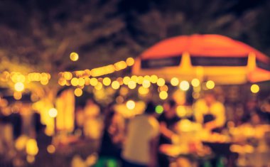 Eskitilmiş ton bulanıklığı, arka plan kullanımı için Bokeh ile gece festivalindeki yemek tezgahının görüntüsü .