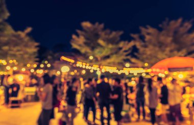 Eskitilmiş ton bulanıklığı, arka plan kullanımı için Bokeh ile gece festivalindeki yemek tezgahının görüntüsü .