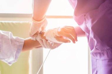 Çocuk eli görüntüsü. Hastaların ateşi var. Hemşireyle serum fizyolojik tüpü var..