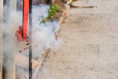 Kırmızı kestane fişekleri sarkıyor, ateşi yakıyor ve gürültüyü Çin Yeni Yılı 'nda yayıyor..