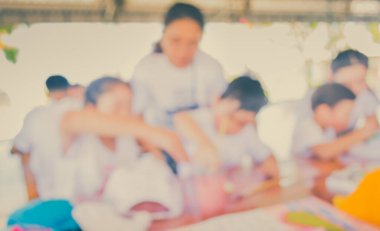 Arka plan kullanımı için parlak güneşli oyun odasında annesiyle resim çizen bulanık çocuk ve anne görüntüsü. (Klasik ton))