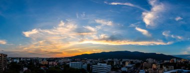 Modern Chiang Mai şehrinin üstündeki gökyüzünün panorama görüntüsü ve Doi Suthep dağının akşam vakti yüksek açılı manzarası.