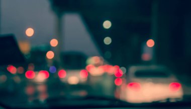 Arka plan için gece vakti trafik sıkışıklığından gelen bokeh ışıkları olan içerideki arabaların klasik ton bulanık görüntüsü.