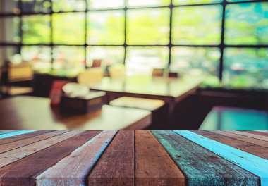 Arkaplan kullanımı için ahşap masa ve bulanık restoran yüzeyine seçici odaklı ton görüntüsü.