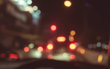 Arka plan kullanımı için gece vakti araba kullanan insanların klasik ton bulanık görüntüsü. (içeriden fotoğraf çek)