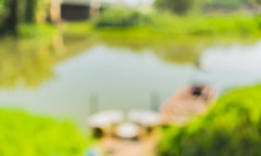 Arkaplan kullanımı için gündüz vakti bulanık nehir ve yeşil bahçe görüntüsü .