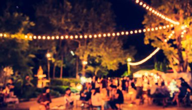 Eskitilmiş ton bulanıklığı, arka plan kullanımı için Bokeh ile gece festivalindeki yemek tezgahının görüntüsü .