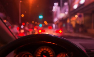 Arka plan kullanımı için gece vakti ışık saçan içerideki arabanın bulanık görüntüsü. (mor ton))