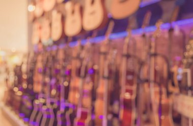 Geçmişe dönük kullanım için Bokeh ile müzikal enstrüman dükkanının soyut bulanık görüntüsü. (Klasik ton))