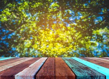 Ahşap tablo ve klasik ton görüntüsü arka plan kullanımı için güneş alan soyut Bokeh yeşil ağaç.