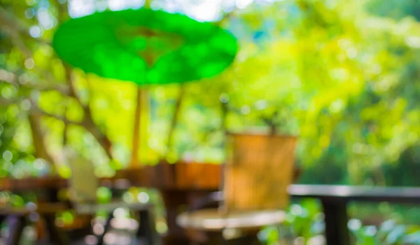 image of blur outdoor restaurant on day time with green tree bokeh for background usage .