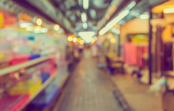 blur image of night market on street with bokeh for background usage (vintage tone)