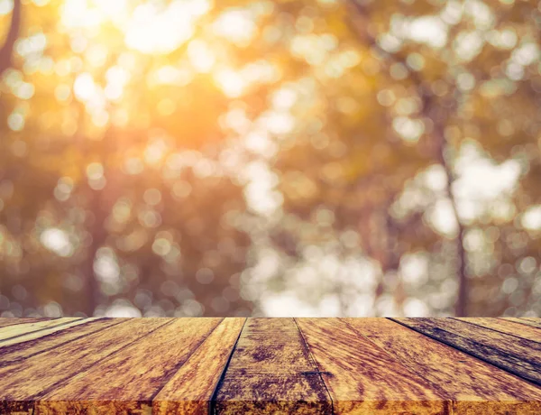 木桌和抽象模糊形象的绿树Bokeh与太阳为背景使用 复古音 — 图库照片