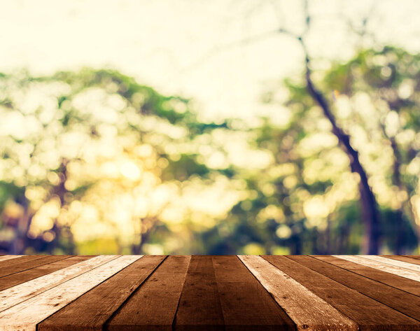 Blurred images of wood table and forests with the sky as a backdrop.