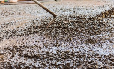 İnşaat alanında zemine beton döken işçilerin görüntüsü.