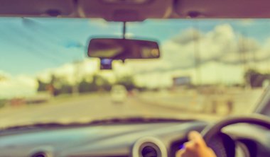 Arka plan kullanımı için gündüz vakti araba kullanan insanların soyut bulanık görüntüsü. (Klasik ton))