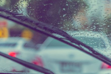 Akşamları araba kullanan, cam üzerine yağmur damlası ve arka plan kullanımı için silecek kullanan insanların klasik ton görüntüsü. (içeriden fotoğraf çek)