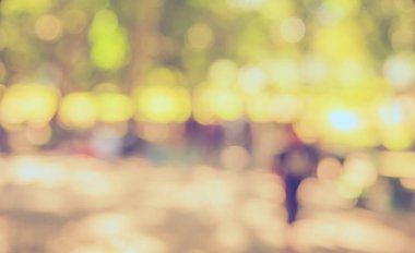 Bokeh 'in arka plan kullanımı için gündüz vakti bahçedeki yürüyüş yolunun soyut bulanık görüntüsü. (Klasik ton))