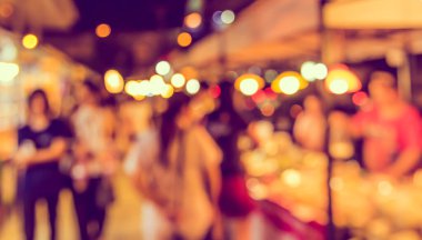 Gece festivalinde arka plan kullanımı için Bokeh ile birlikte sokak pazarının soyut bulanık görüntüsü. (Klasik ton))