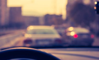 Arka plan kullanımı için gündüz vakti araba kullanan insanların klasik ton bulanık görüntüsü. (içeriden fotoğraf çek)