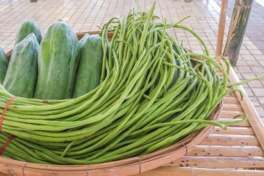 Yerel Tayland pazar saatinde bambu masasında satılık sebze resmi.