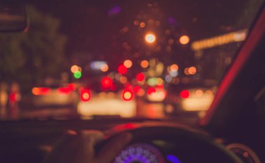 Arkaplan kullanımı için, yağmurlu gecelerde bokeh ışıkları olan içerideki arabaların klasik ton bulanık görüntüsü .