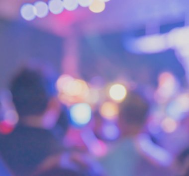 Canlı müzik grubuyla konser salonundaki insanların bulanık görüntüsü.