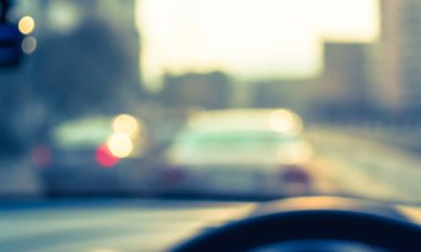 Arka plan kullanımı için gündüz vakti araba kullanan insanların klasik ton bulanık görüntüsü. (içeriden fotoğraf çek)