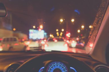 Arka plan kullanımı için gece vakti araba kullanan insanların klasik ton bulanık görüntüsü. (içeriden fotoğraf çek)