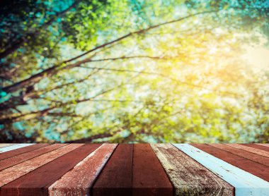 Ahşap tablo ve klasik ton görüntüsü arka plan kullanımı için güneş alan soyut Bokeh yeşil ağaç.