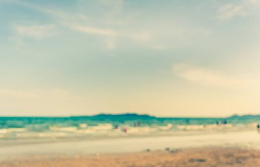 Arka plan kullanımı için sahilde yürüyen bulanık insanların soyut görüntüsü. (Klasik ton))