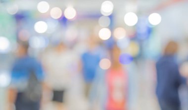 Alışveriş merkezinde veya sergi salonunda arka plan kullanımı için Bokeh ile yürüyen insanların soyut bulanık görüntüsü .