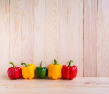 Ahşap masa arkasında tatlı biber resmi.