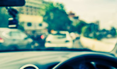 Arka plan kullanımı için gündüz vakti araba kullanan insanların klasik ton bulanık görüntüsü. (içeriden fotoğraf çek)