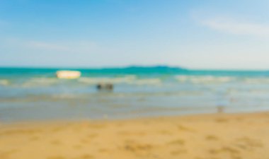 Arka plan kullanımı için sahilde yürüyen bulanık insanların soyut görüntüsü .