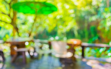 Arka plan kullanımı için yeşil ağaç bokeh ile gündüz vakti bulanık bir restoran görüntüsü .