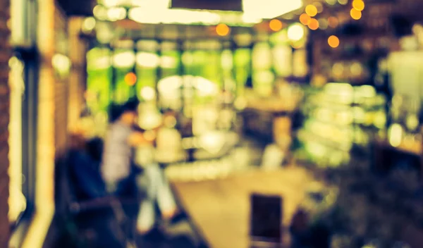 image of blur Coffee and bakery shop with bokeh for background usage. (vintage tone)