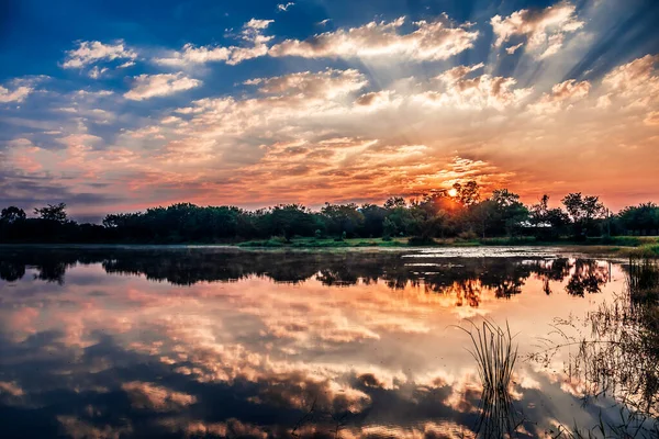 人类发展报告 中的湖水和草场图像 黎明时分有日出 — 图库照片