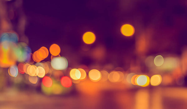 Vintage tone abstract blur image of street night bokeh for background usage .