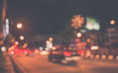 Arka plan kullanımı için gece vakti yolda bulanık bir araba görüntüsü. (Klasik ton))