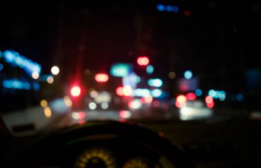 Arka plan kullanımı için gece vakti araba kullanan insanların klasik ton bulanık görüntüsü. (içeriden fotoğraf çek)