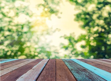 Arkaplan kullanımı için ahşap tablo ve yeşil ağaç bokeh 'in soyut bulanık resmi .