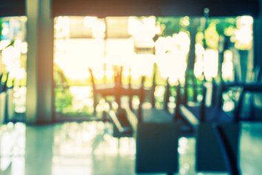 Arka plan için kapalı kahve dükkanındaki masa ve sandalyelerin klasik ton bulanık görüntüsü.